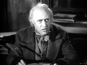 Ebenezer Scrooge, portrayed by Alistair Sim in the 1951 film adaptation of Dickens' A Christmas Carol.
